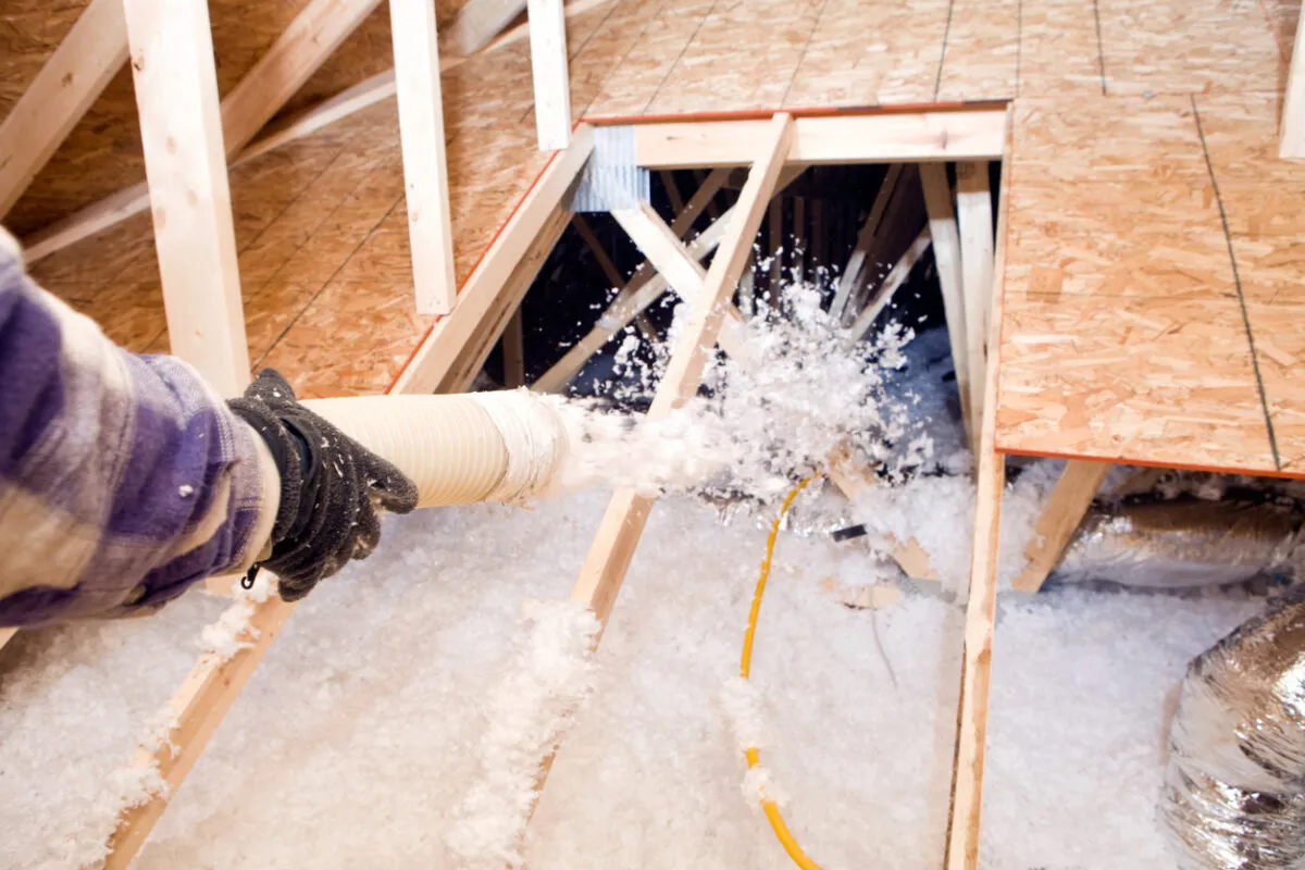 Blown-in-insulation-being-installed-between-attic-trusses-e1665993683696